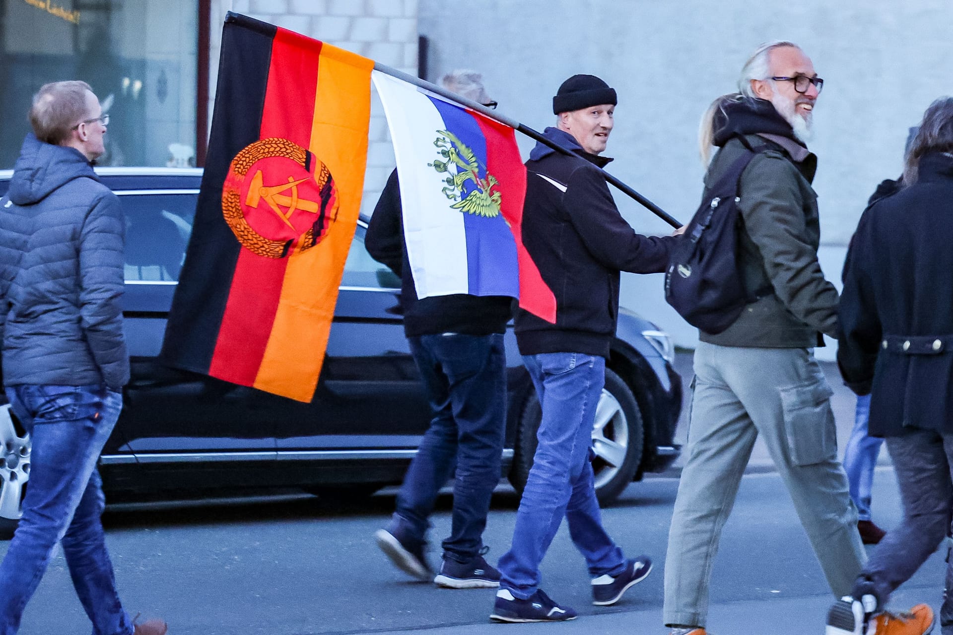 Ein Teilnehmer einer AfD-Demonstration mit Flaggen der DDR und Russland (Archivbild).