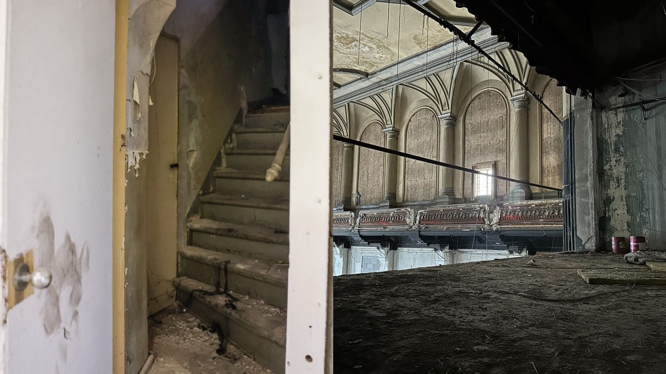 Links eine Treppe, die hinter einer Wand entdeckt wurde. Rechts der Blick von der Bühne.