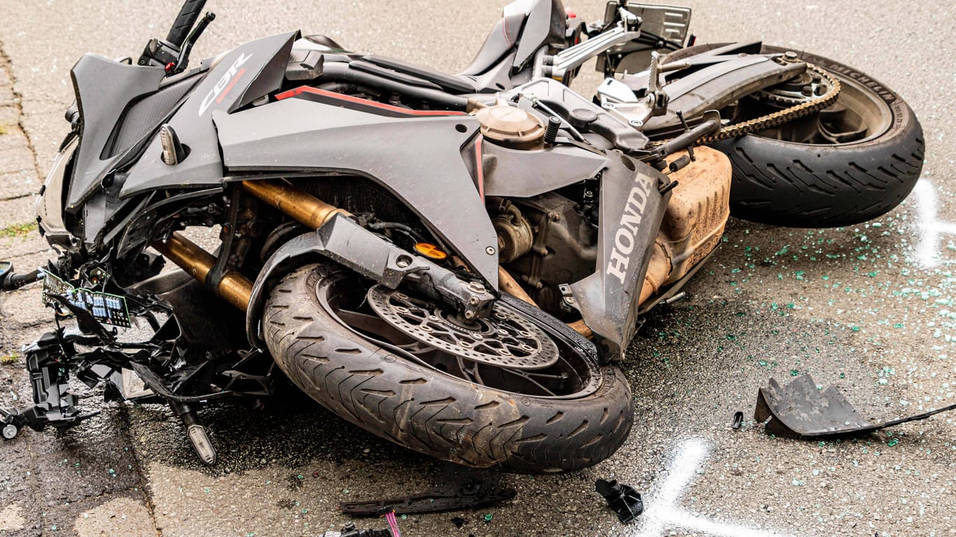 Ein Motorrad liegt nach einem Verkehrsunfall stark beschädigt auf einer Straße (Symbolfoto): In Wilhelmsburg ist es zu einem tödlichen Zusammenstoß zwischen einem Biker und einem E-Bike-Fahrer gekommen.