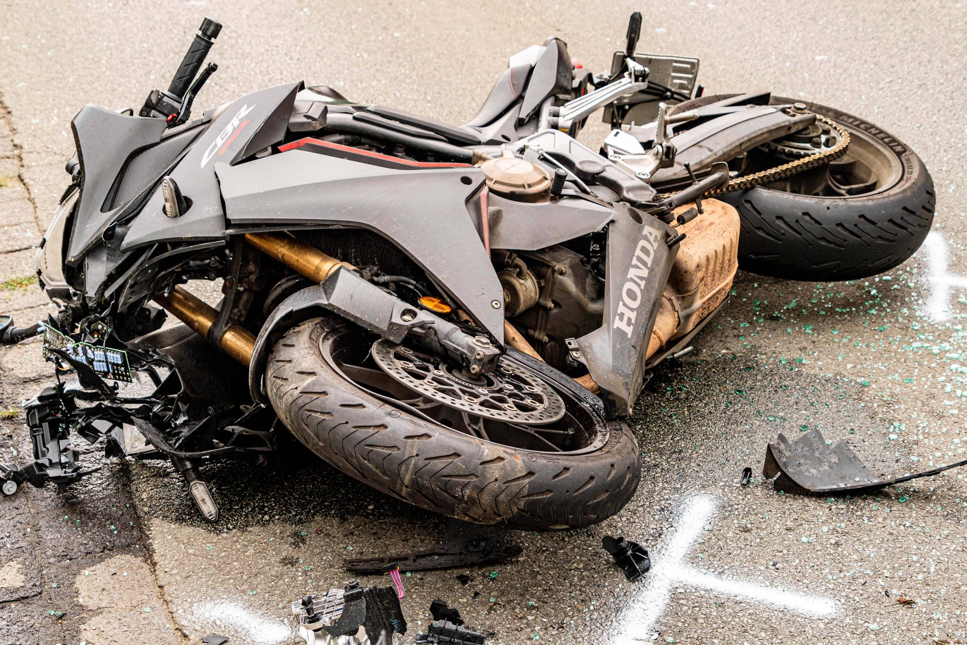 Ein Motorrad liegt nach einem Verkehrsunfall stark beschädigt auf einer Straße (Symbolfoto): In Wilhelmsburg ist es zu einem tödlichen Zusammenstoß zwischen einem Biker und einem E-Bike-Fahrer gekommen.