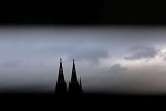 Durch ein Geländer sind die Spitzen des Domes zu sehen (Symbolbild): Im Klageverfahren gegen das Erzbistum Köln gibt es am Dienstag noch keine Entscheidung.