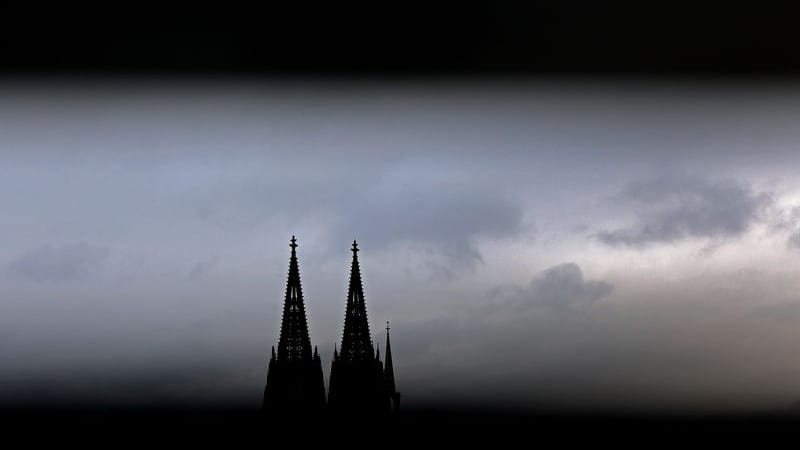 Durch ein Geländer sind die Spitzen des Domes zu sehen (Symbolbild): Im Klageverfahren gegen das Erzbistum Köln gibt es am Dienstag noch keine Entscheidung.