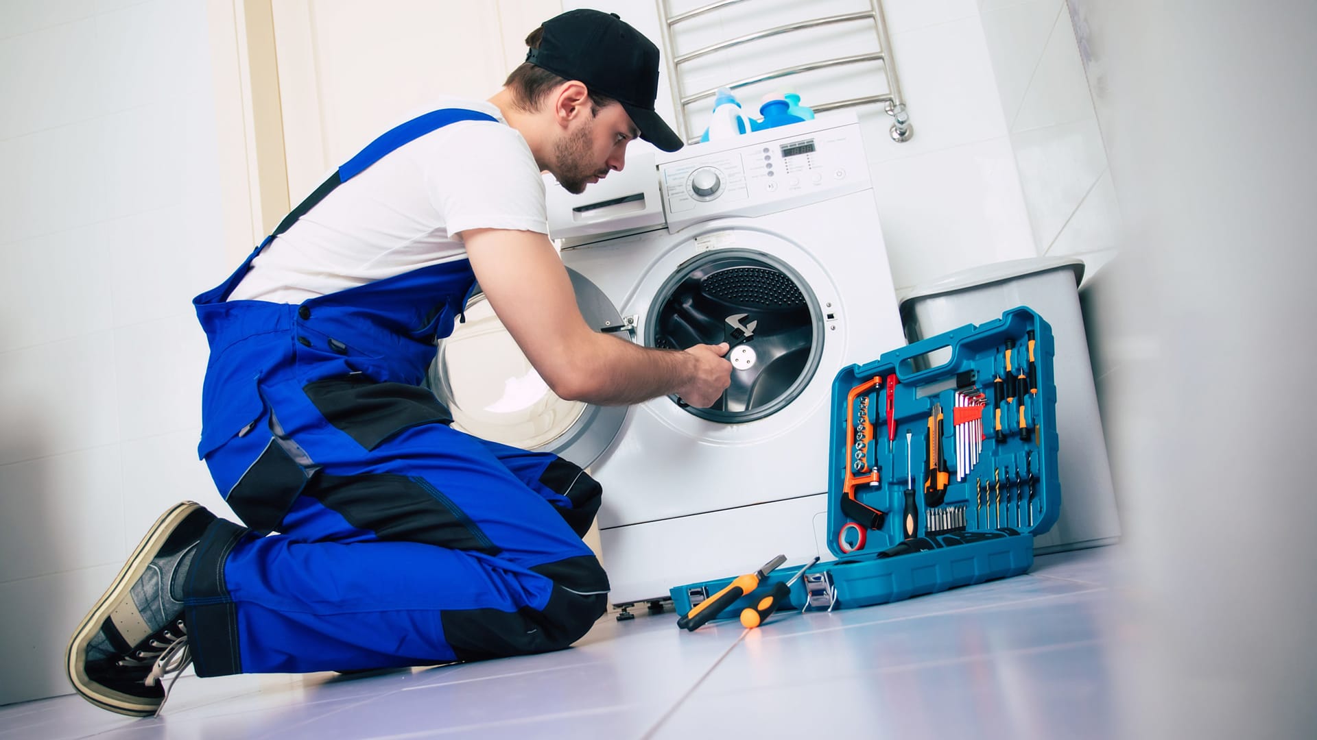 Ein Mann repariert eine Waschmaschine (Symbolbild): Der Berliner Senat fördert Elektro-Reparaturen.