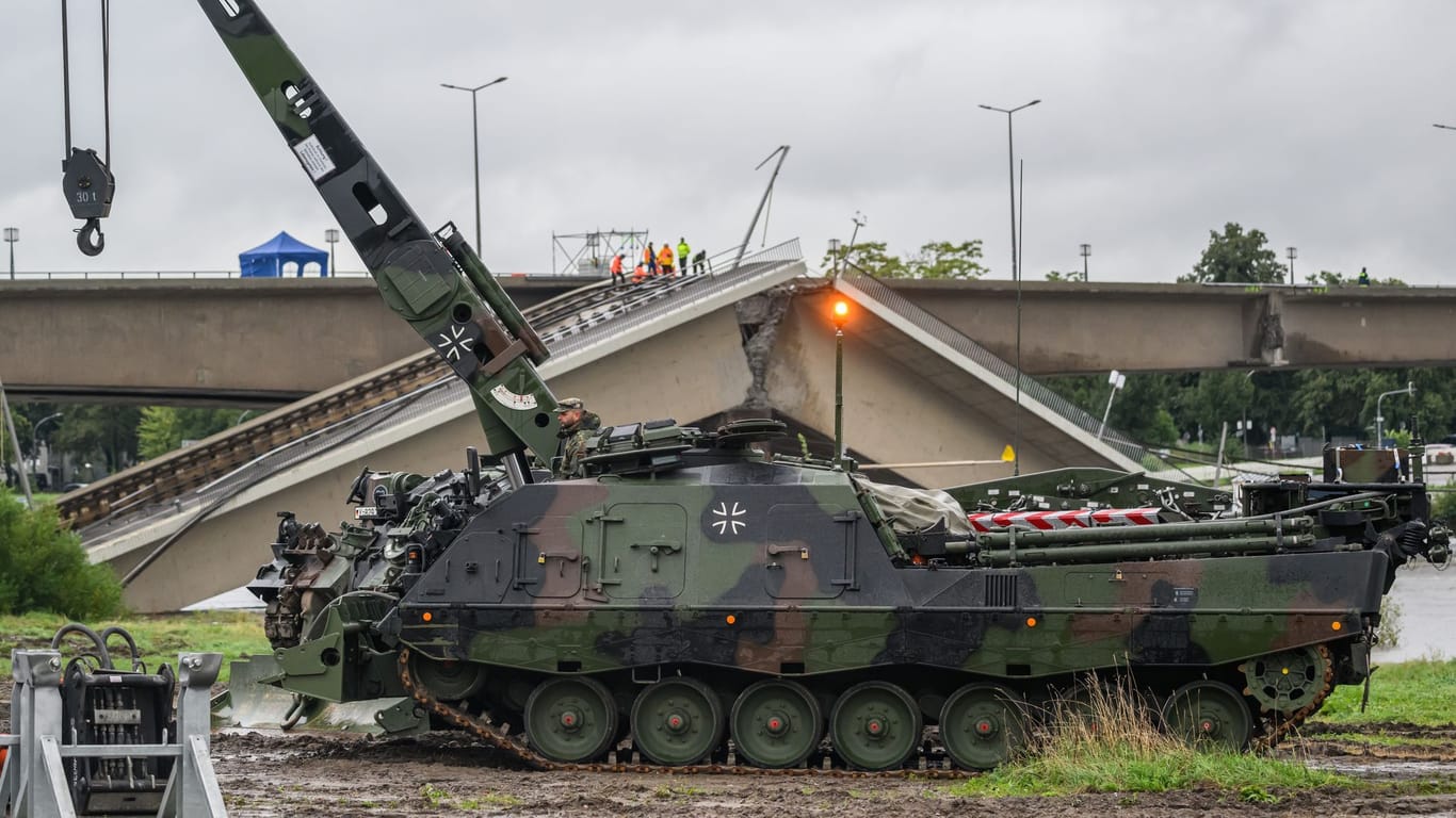 , Sachsen, Dresden: Ein Bergepanzer 3 der Bundeswehr, auch «Büffel» genannt, steht vor der historischen Altstadtkulisse neben der eingestürzten Carolabrücke, um im Fall eines Hochwassers Baumaschinen zu bergen. Im Zuge von Abrissarbeiten ist ein weiterer Abschnitt der Carolabrücke in Dresden eingebrochen.