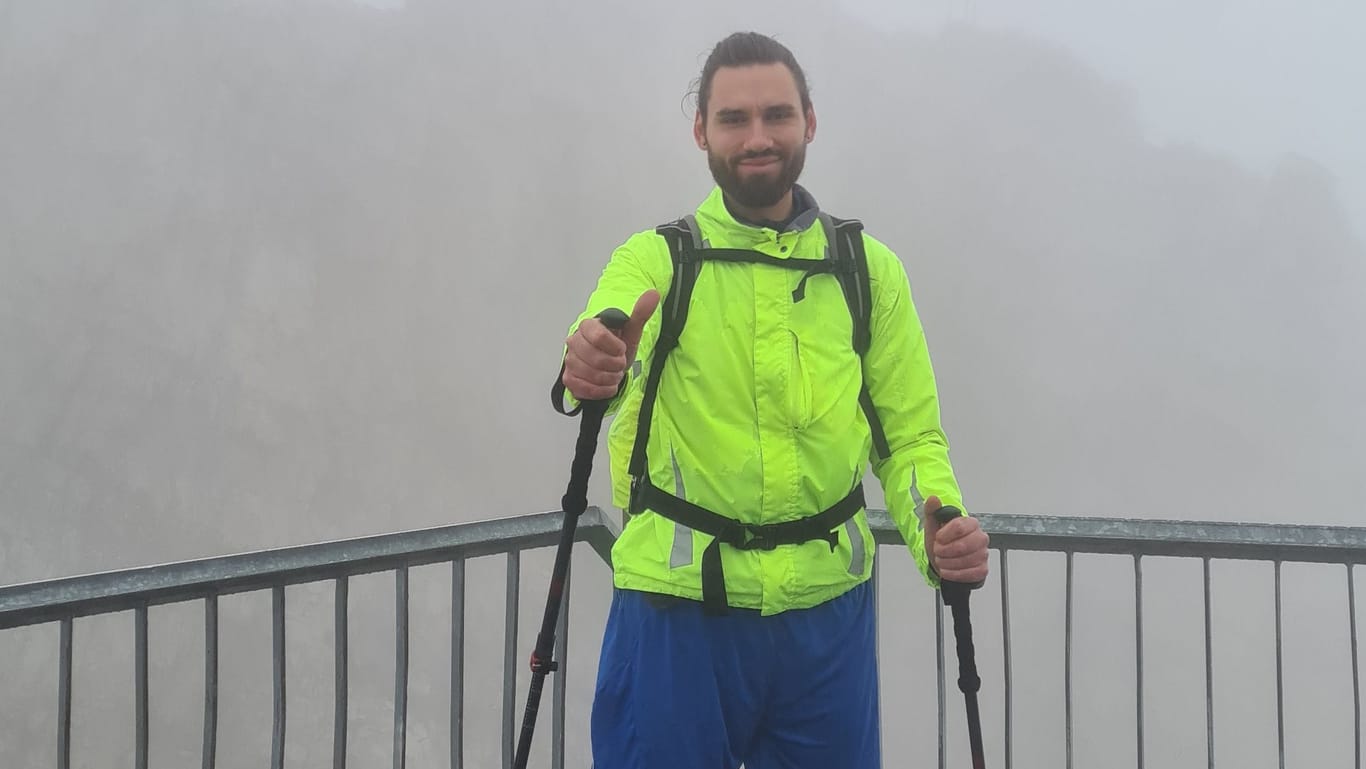 Am Ziel angekommen: Das Gipfelkreuz ist im dichten Nebel fast vollständig verschwunden.