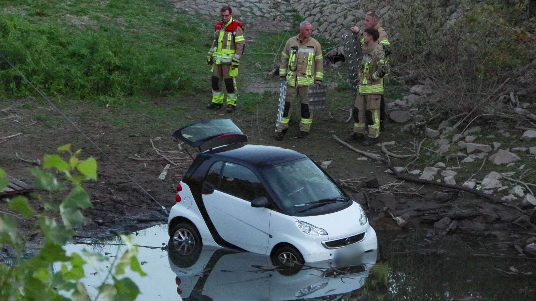 Kurioser Unfall am Rhein: Smart rollte Uferböschung runter und l