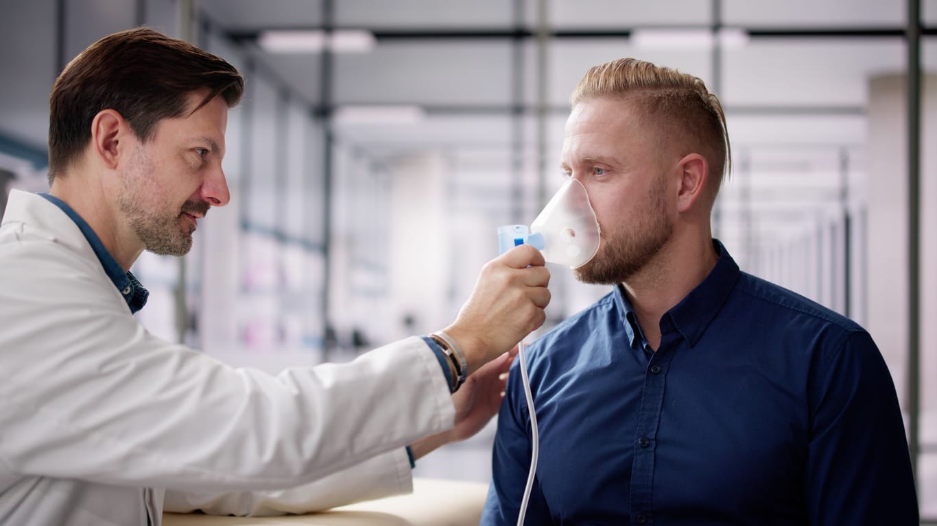 Ein Arzt leitet ein Patient im Gebrauch einer COPD Atemaske an.