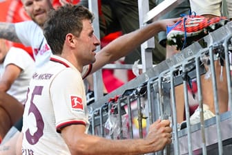 Geschenk an die Fans: Thomas Müller überreicht seine Fußballschuhe in der Fankurve.