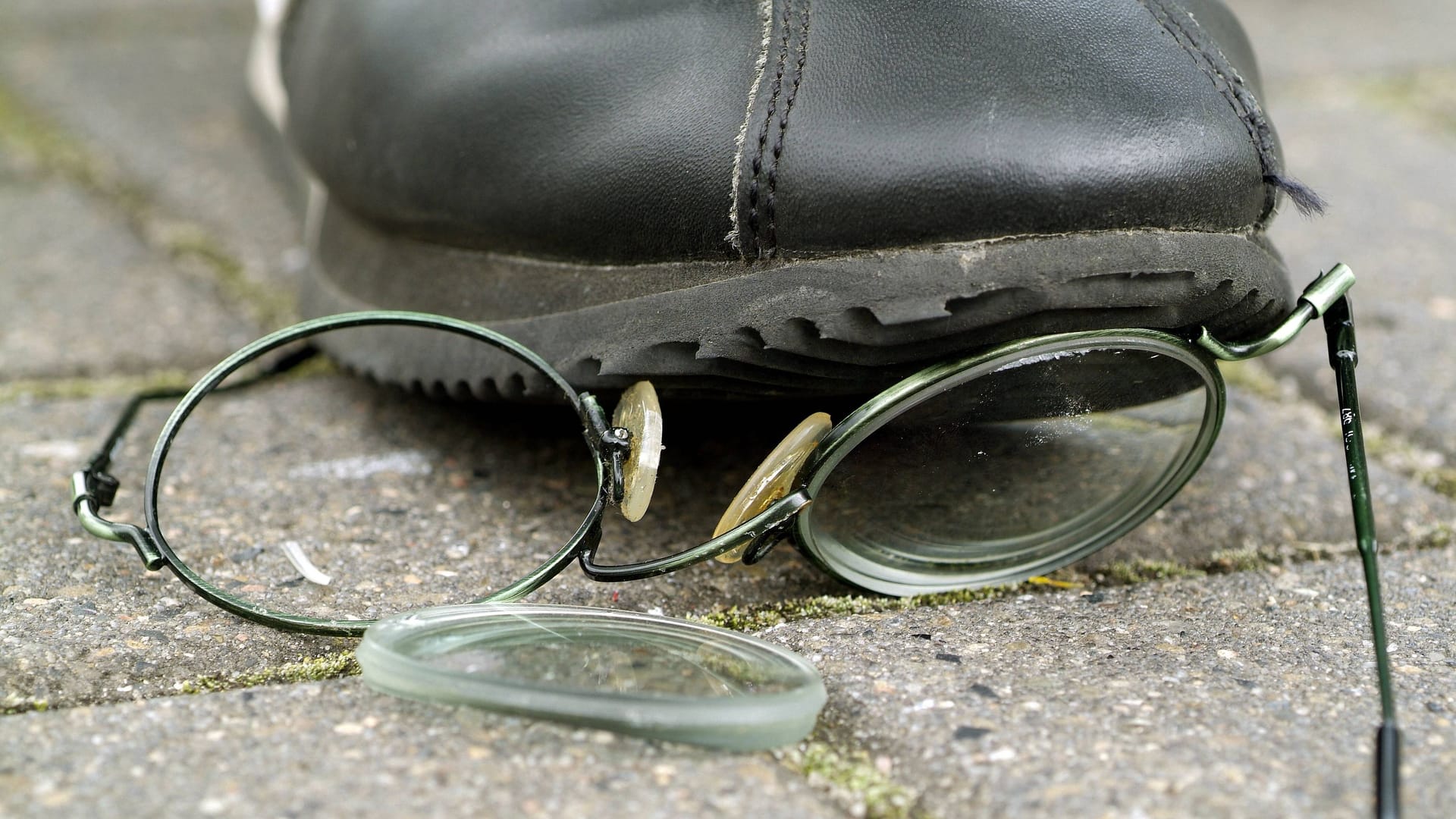 Eine Person tritt auf eine am Boden liegende Brille (Symbolbild): Ein Anhänger des 1. FC Köln wurde nach einem Pokalspiel des Frauenteams gewaltsam attackiert.