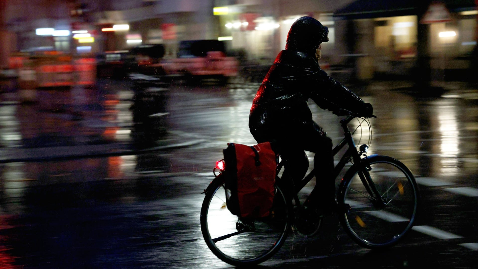 Eine Radfahrerin quält sich durchs dunkle, verregnete Berlin: Ihr Fahrradlicht funktioniert.