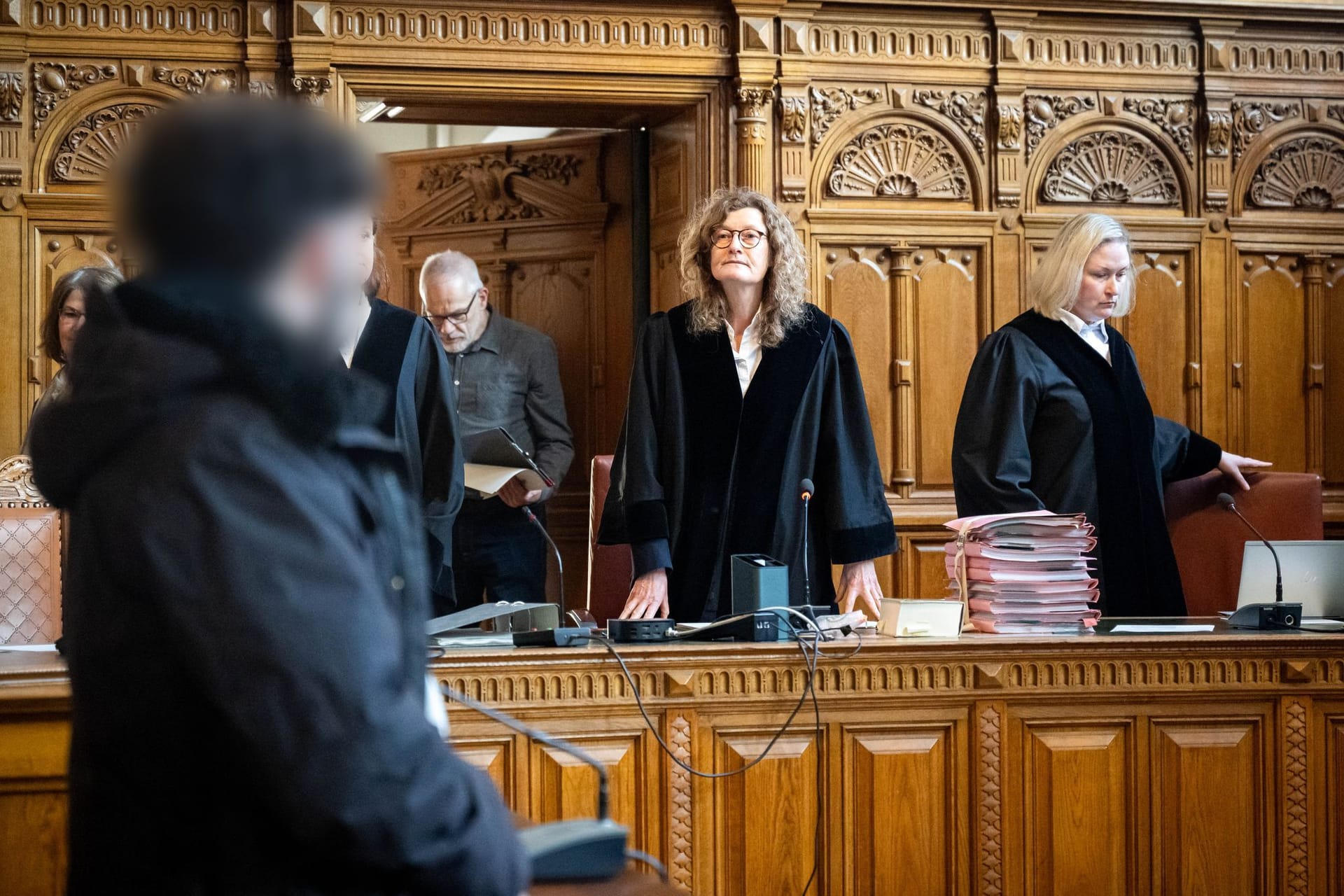 Der Angeklagte (l) im Prozess wegen Totschlags steht vor Prozessbeginn im Gerichtssaal. Dem Mann wurde vorgeworfen, einen Menschen mit einem Sprung auf den Kopf getötet zu haben.