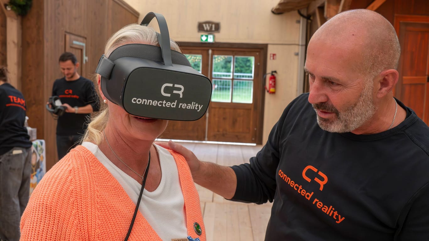 Frau mit VR-Brille neben dem VR-Filmer Christoph Ostler: Auf dem Oktoberfest zeigte Vr4Kids, wie Kinder mit Behinderung virtuell auf die Wiesn gehen können.