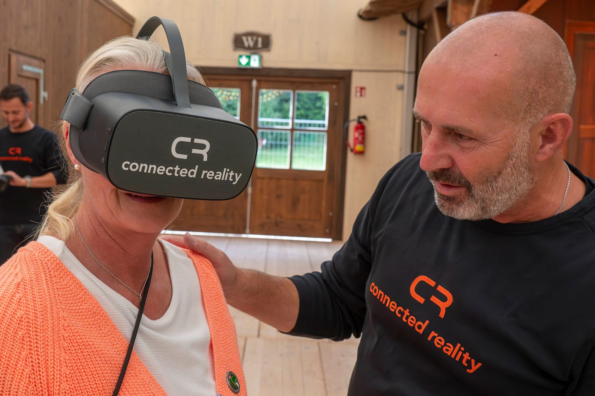 Frau mit VR-Brille neben dem VR-Filmer Christoph Ostler: Auf dem Oktoberfest zeigte Vr4Kids, wie Kinder mit Behinderung virtuell auf die Wiesn gehen können.