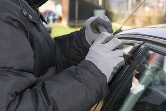 Ein Mann versucht, eine Autotür aufzuhebeln (Symbolbild): In Dortmund hat die Polizei einen Dieb festgenommen.