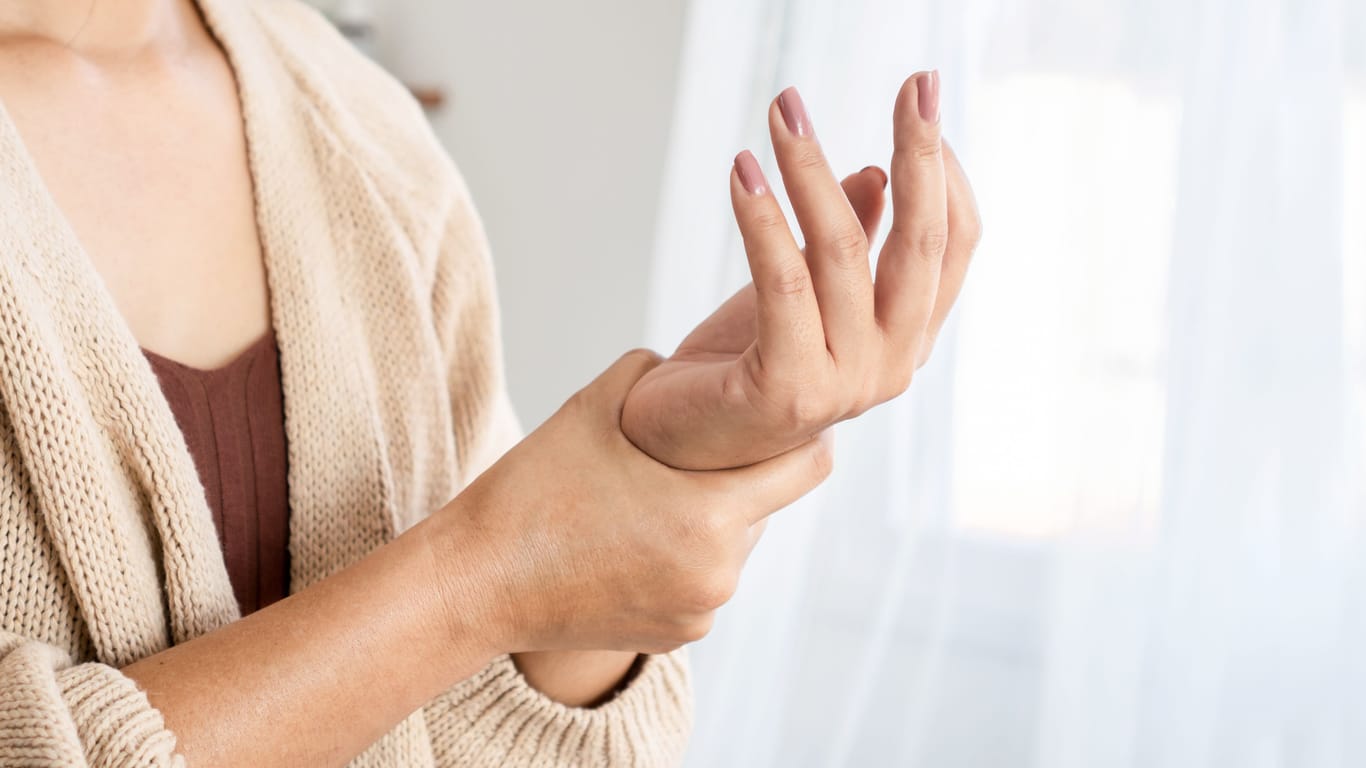 Frau mit Schmerzen in der Hand: Nach einer Schnappfinger-OP verbessert sich die Beweglichkeit manchmal nicht so rasch wie erwartet.