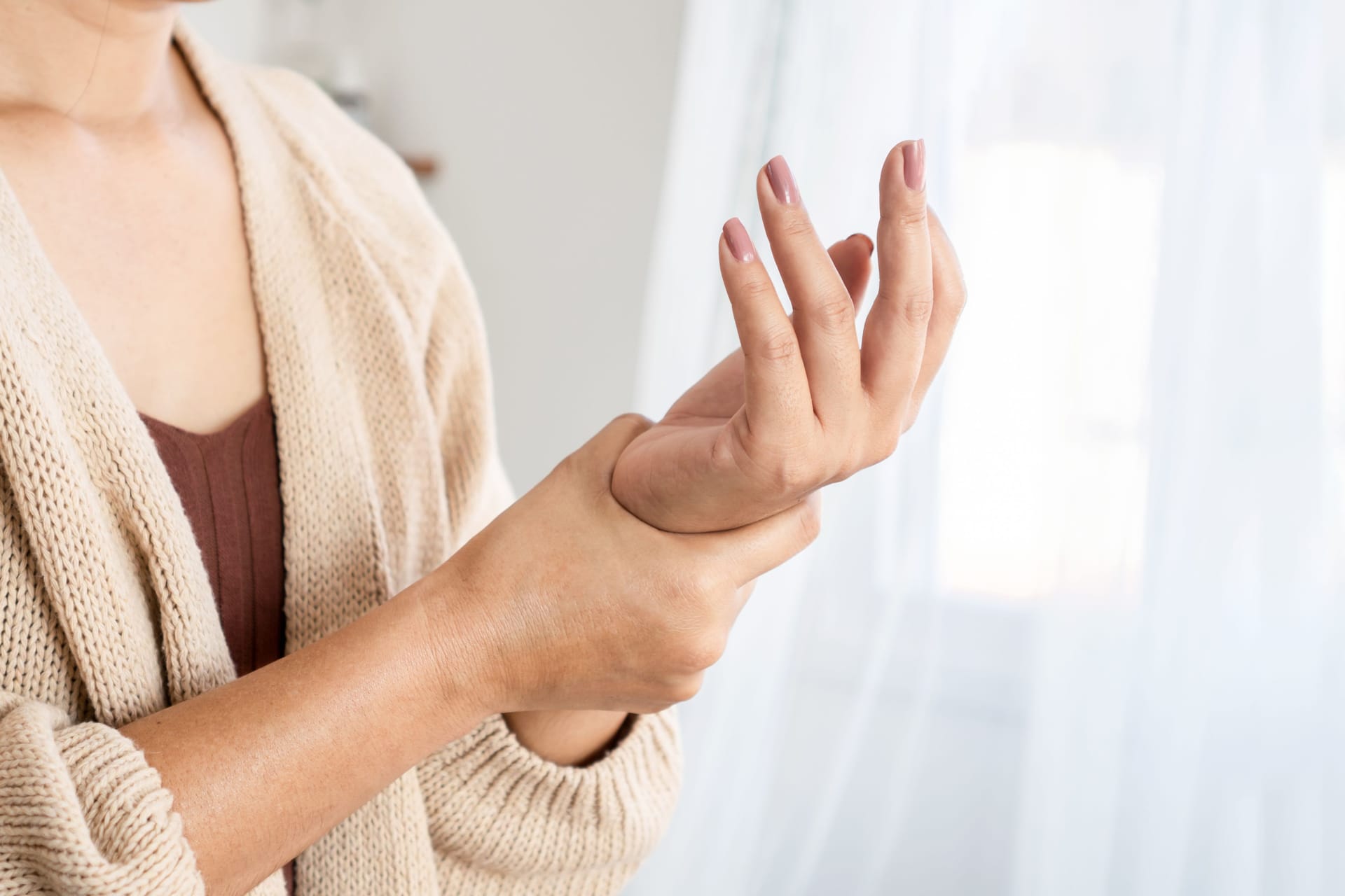 Frau mit Schmerzen in der Hand: Nach einer Schnappfinger-OP verbessert sich die Beweglichkeit manchmal nicht so rasch wie erwartet.