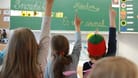 Kinder melden sich im Schulunterricht (Symbolbild): Eine neue Studie zeigt, wie die Bremer die Schulen im Land bewerten.