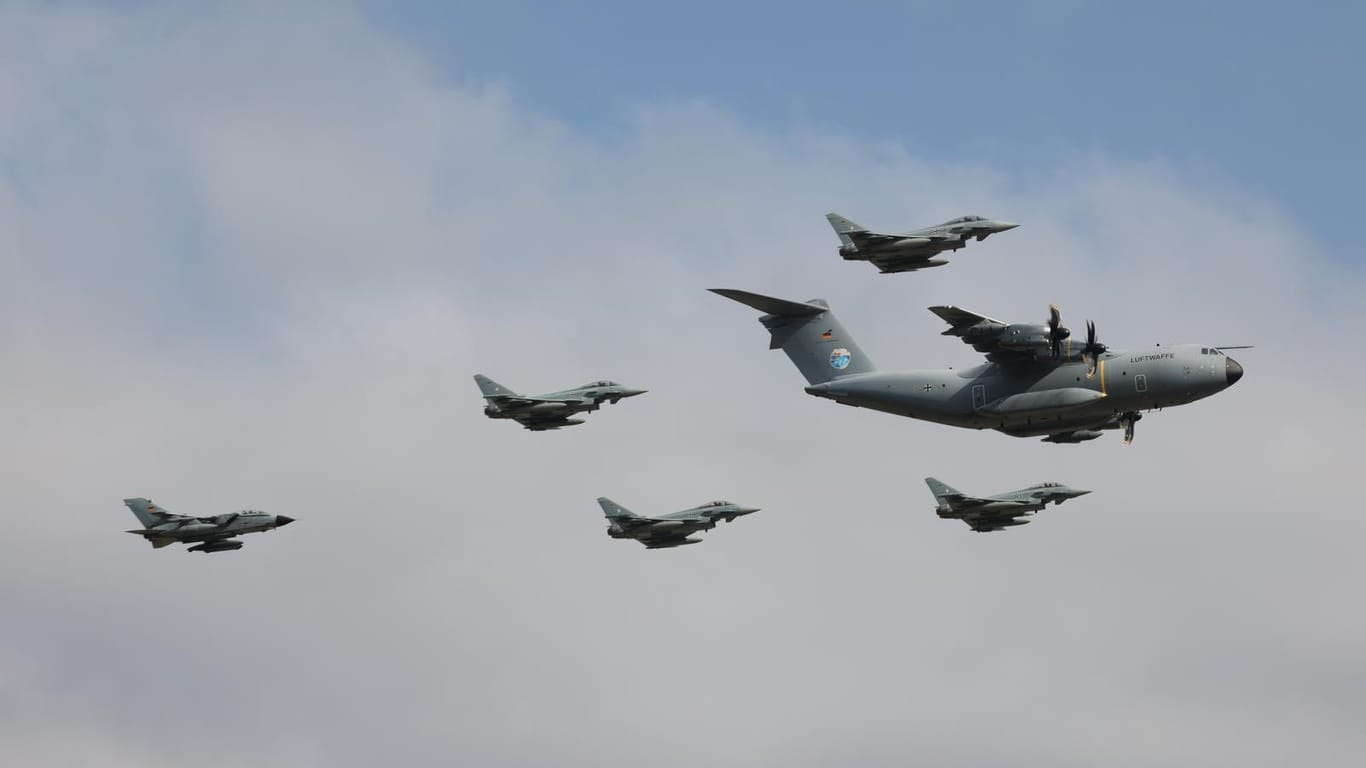 Vier Eurofighter der deutschen Luftwaffe begleiten mit einem Tornado-Kampfjet einen Airbus A400M. Die Militärmaschinen sind in enger Formation über Köln hinweggeflogen.