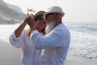 Ein älteres Paar genießt den Strandurlaub (Symbolfoto).