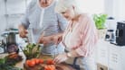 Ein Paar höheren Alters bereitet gemeinsam einen Salat zu