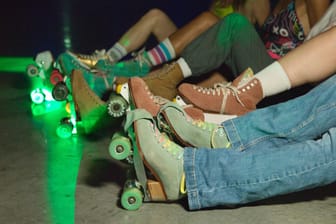 Rollschuhfahrer sitzen auf dem Boden (Symbolbild): Abends verwandelt sich die Halle in eine Roller-Disco mit Musik und Lichtershow.