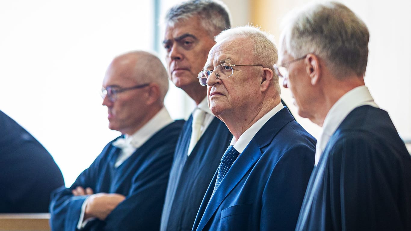 Martin Winterkorn steht in einem Saal des Landgerichts Braunschweig. Neben ihm seine Verteidiger Stefan Kirch (l), Felix Dörr (2.v.l.) und rechts Kersten von Schenk.