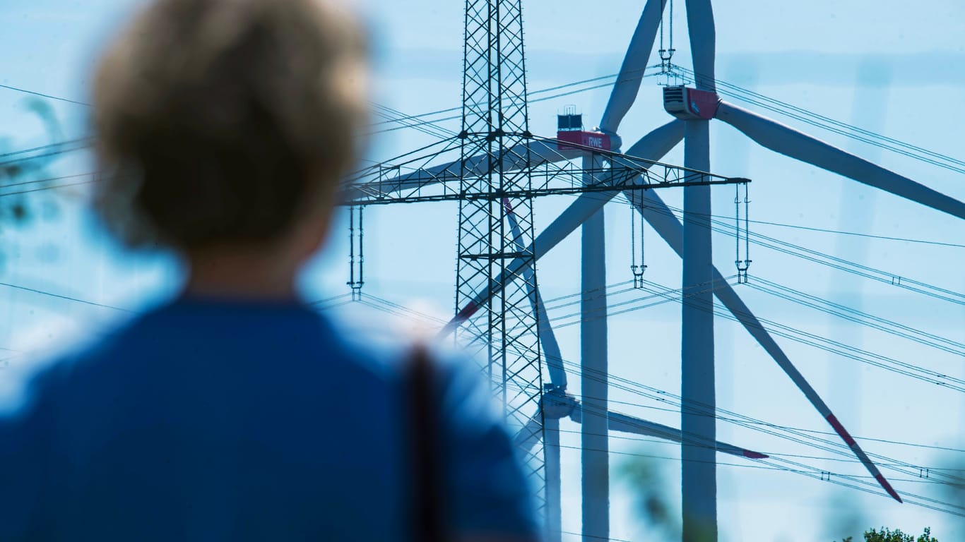 Windräder mit Strommast (Symbolfoto): Hamburg will in den kommenden Jahren mehrere Windräder bauen.