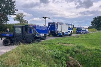 Einsatzkräfte der Polizei und des Technischen Hilfswerks stehen in Gronau: Hier wurden zwei vergrabene Leichen gefunden.