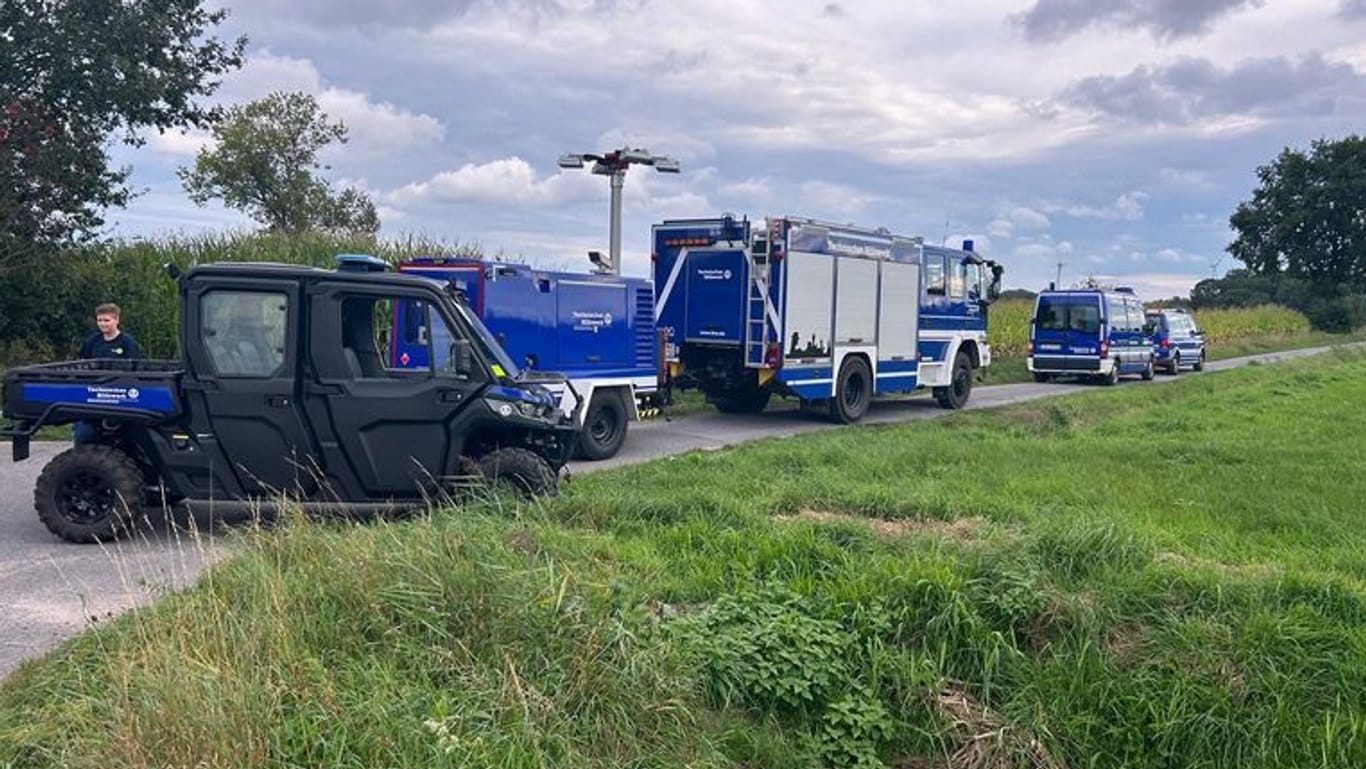 Einsatzkräfte der Polizei und des Technischen Hilfswerks stehen in Gronau: Hier wurden zwei vergrabene Leichen gefunden.