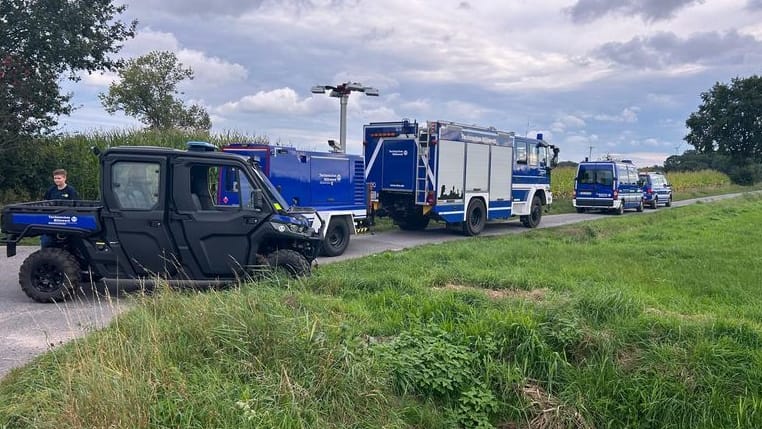 Einsatzkräfte der Polizei und des Technischen Hilfswerks stehen in Gronau: Hier wurden zwei vergrabene Leichen gefunden.