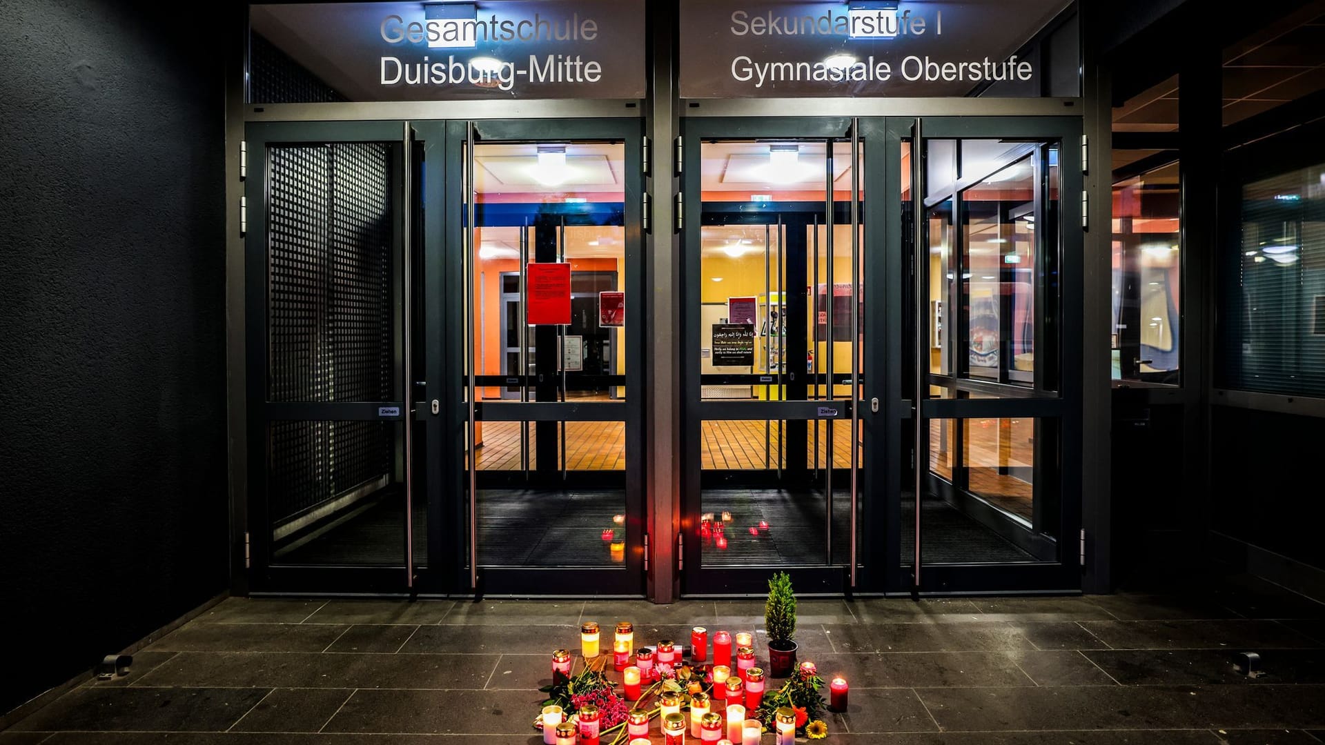 Kerzen stehen am Donnerstagabend vor dem Eingang der Gesamtschule Duisburg-Mitte.