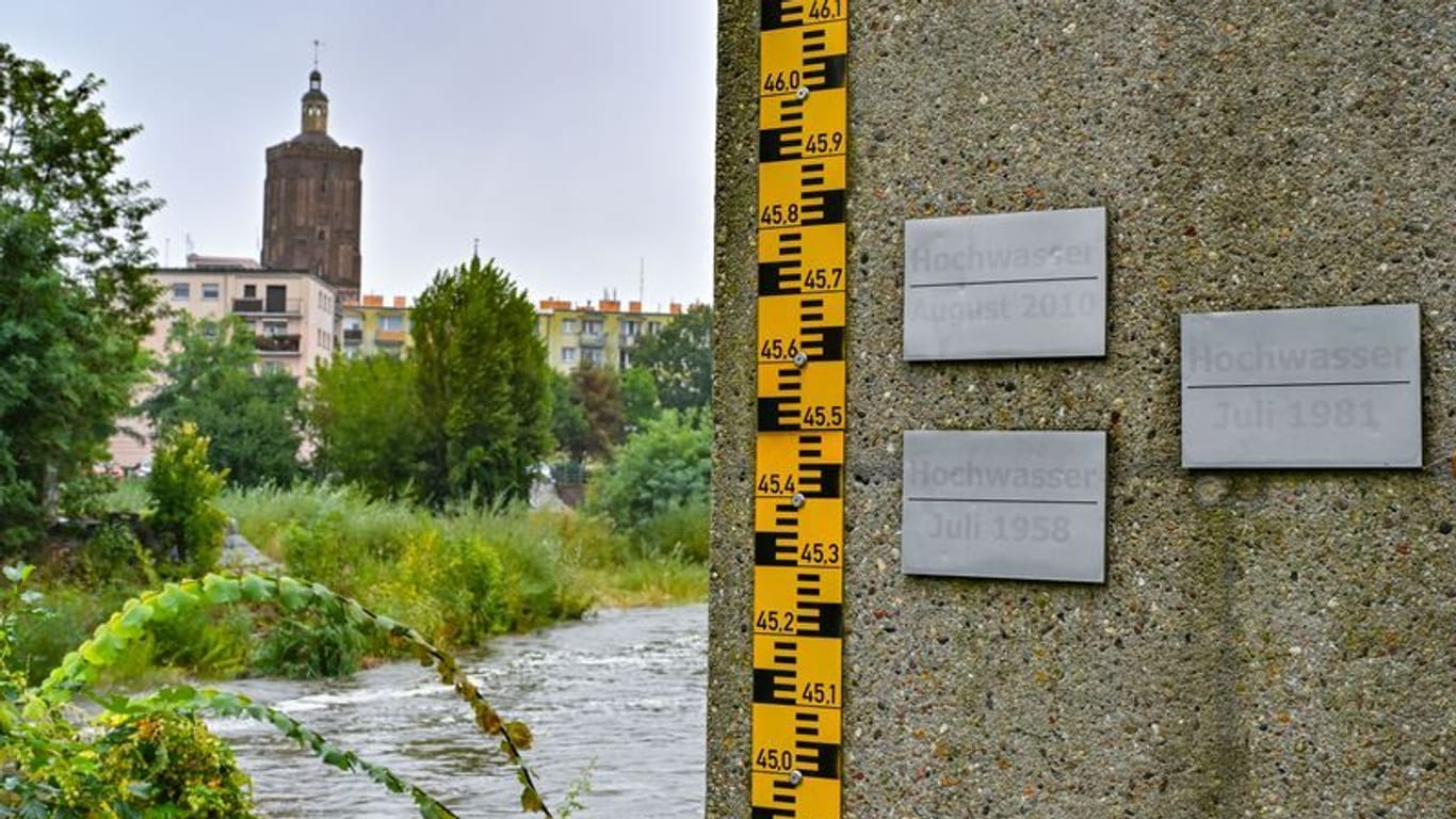 Der deutsch-polnische Grenzfluss Neiße im Stadtzentrum von Guben: An der rechten Bildseite ist eine Pegelmarkierung zu sehen, mit einer Plakette am oberen Rand, die das Hochwasser aus dem Jahr 2010 mit 4,57 Meter markiert.