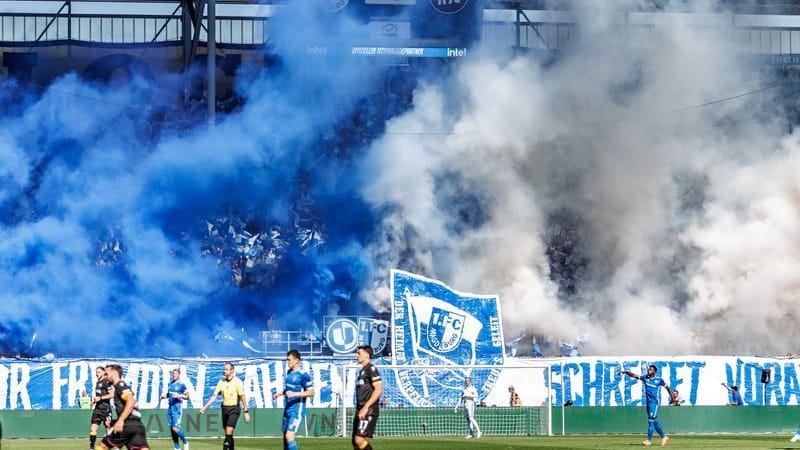 Magdeburger Fans zünden Pyrotechnik auf der Tribüne. Dazu wird das Banner entrollt.