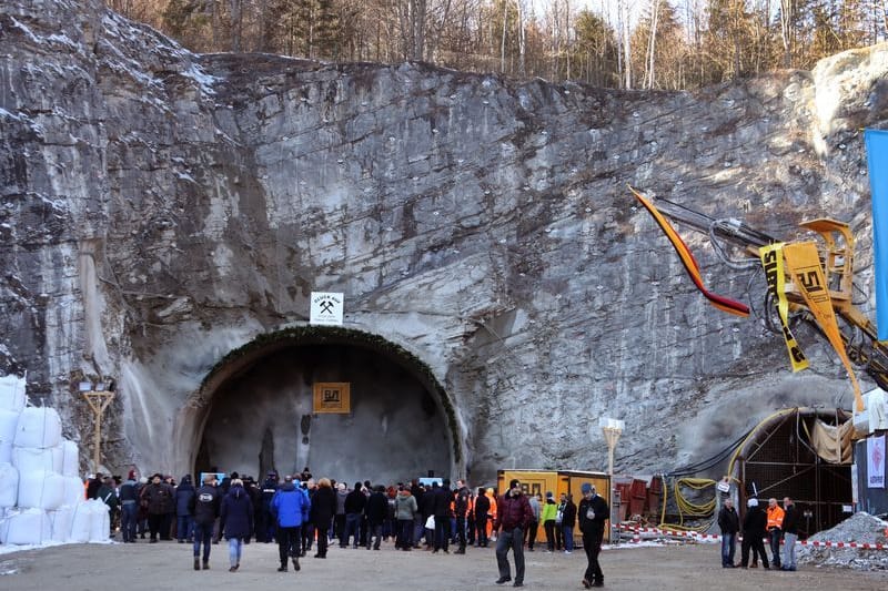 Arbeiter und Gäste stehen nach dem offiziellen Tunnelanschlag vor dem zukünftigen Nordportal des Kramertunnels.