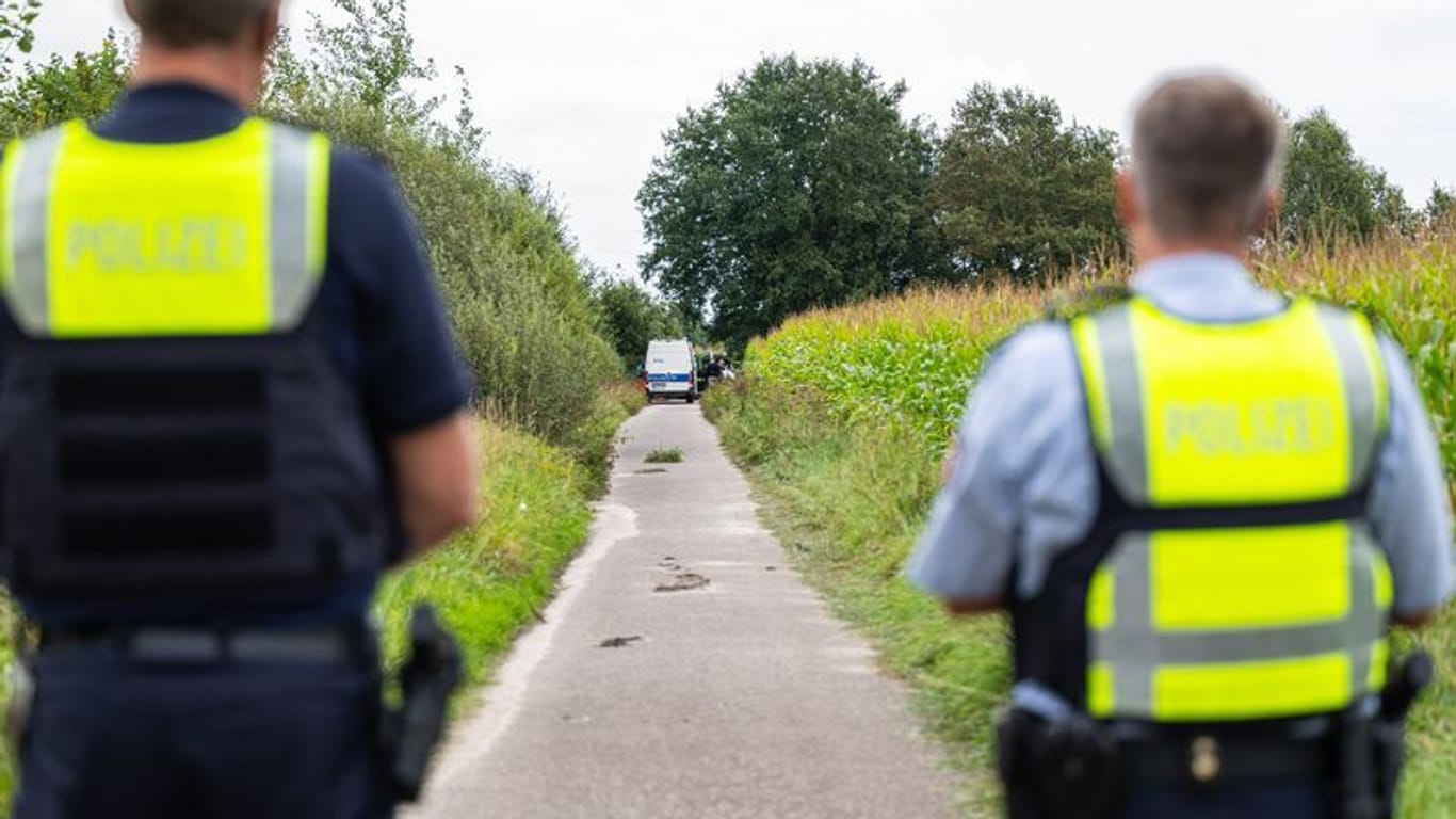 Polizeibeamte stehen am Rande eines Maisfeldes bei Gronau, wo zwei männliche Leichen gefunden wurden.