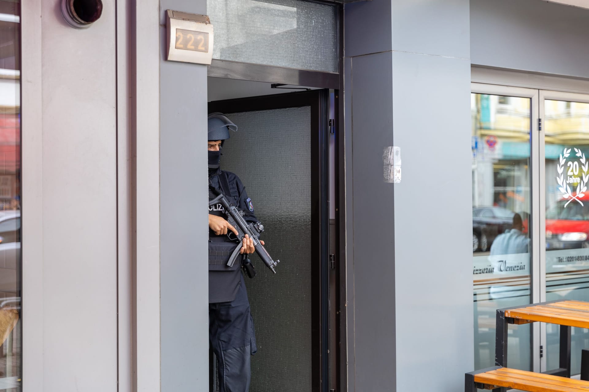 Ein schwer bewaffneter Polizist sichert die Tür zu dem Haus im Essener Südostviertel.