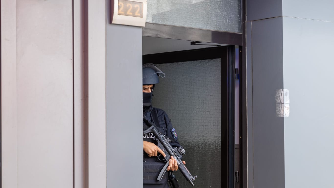 Ein schwer bewaffneter Polizist sichert die Tür zu dem Haus im Essener Südostviertel.