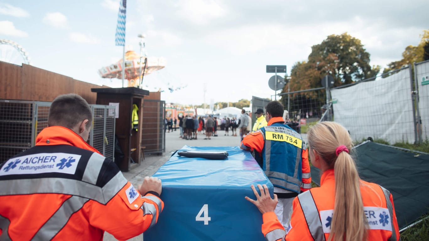 Mitarbeiter der Aicher Ambulanz laufen über das Festgelände (Archivbild): Die Sanitäter haben auf der Wiesn alle Hände voll zu tun.