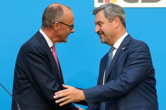 CDU-Chef Friedrich Merz (l.) und CSU-Chef Markus Söder reichen sich die Hand: