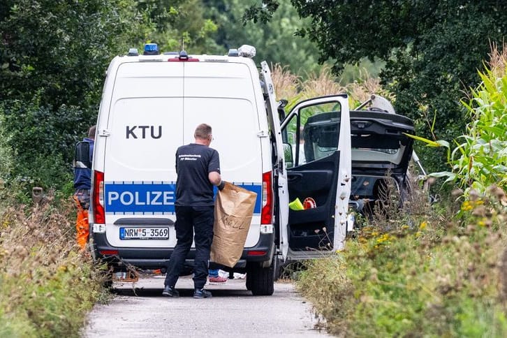 Polizeibeamte am Rande des Maisfeldes: Hier wurden vor einer Woche zwei vergrabene männliche Leichen gefunden.