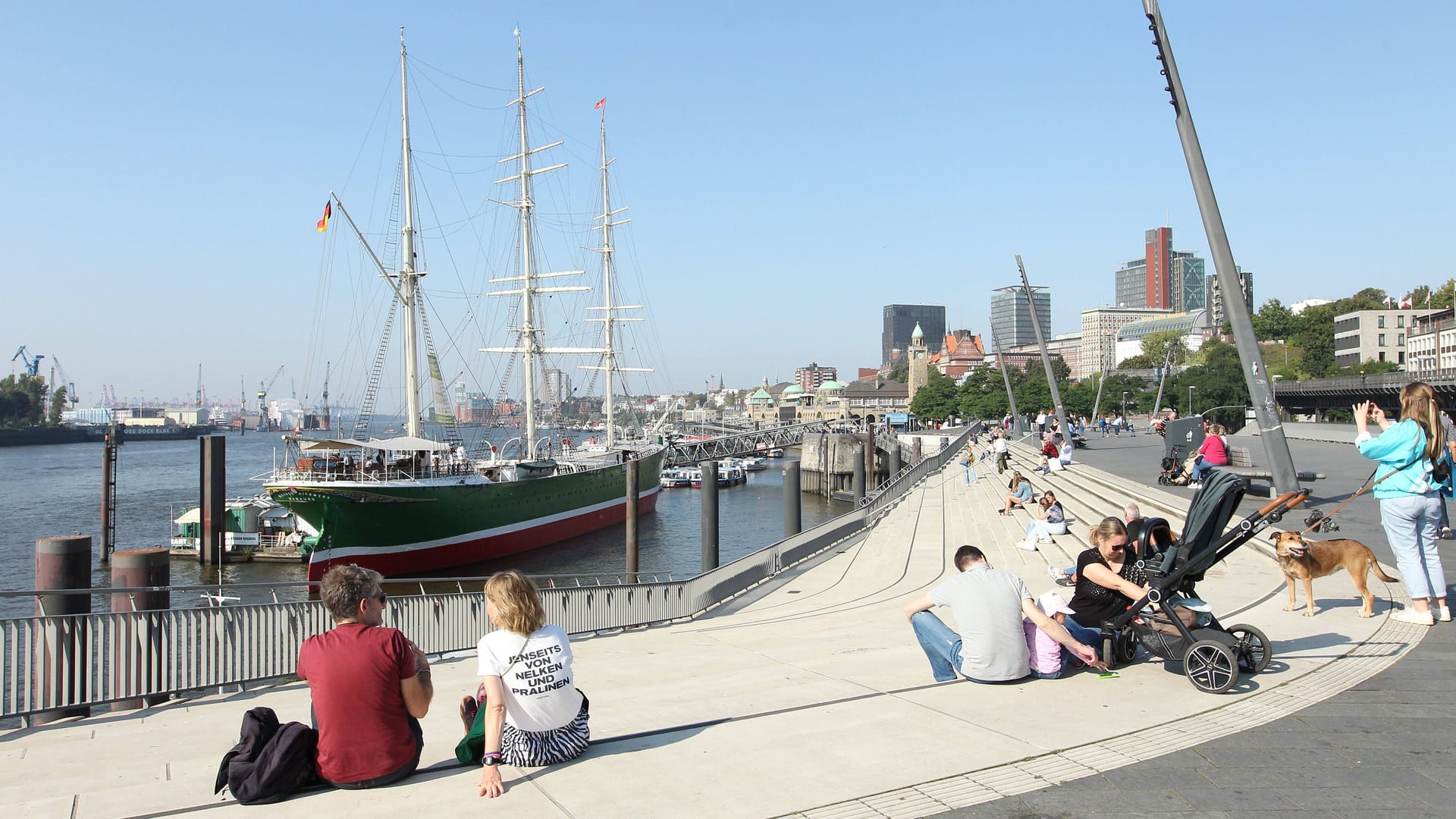 Passanten sonnen sich bei Temperaturen über 20 Grad im Hamburger Hafen: Bald erreicht herbstliches Wetter den Norden.