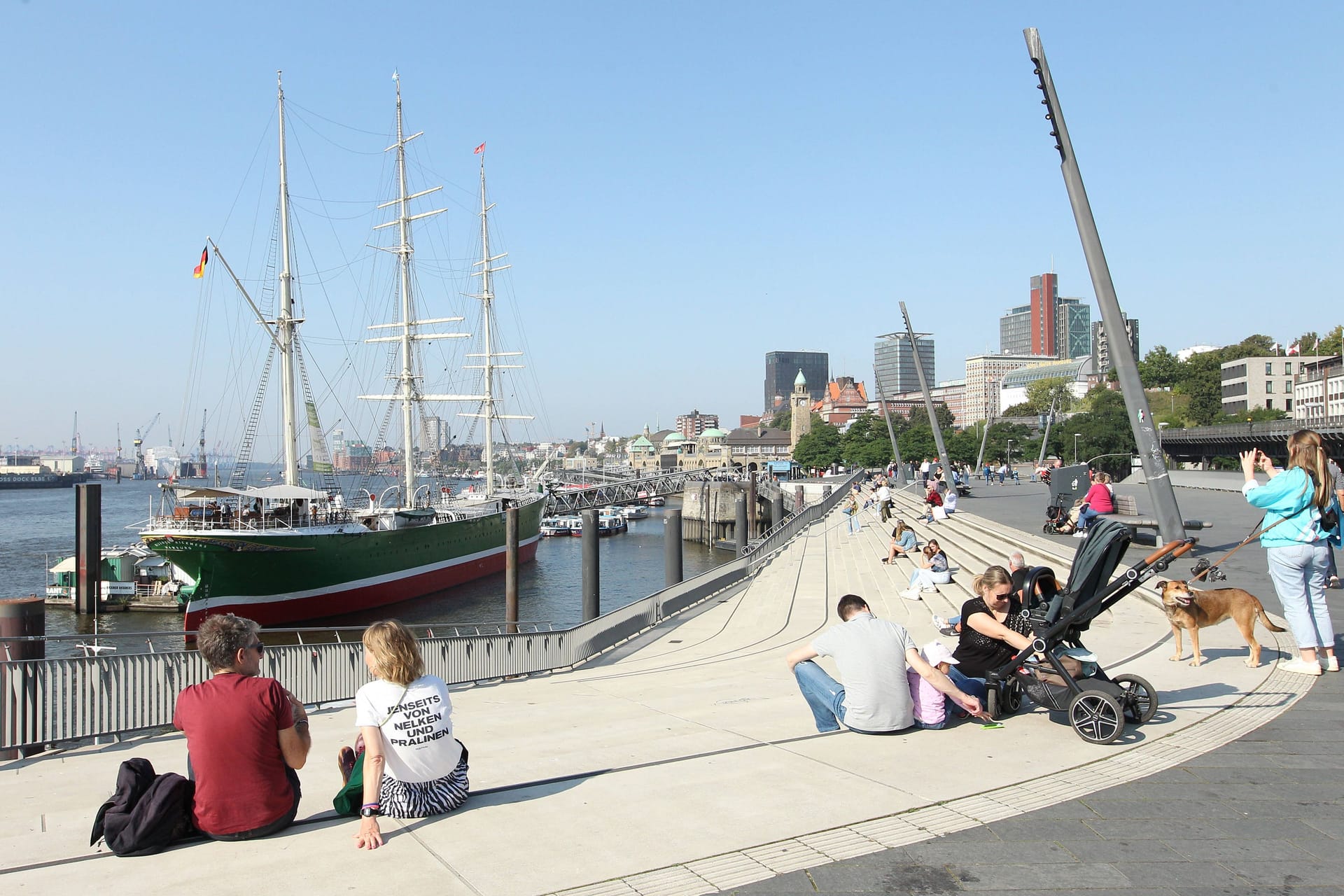 Passanten sonnen sich bei Temperaturen über 20 Grad im Hamburger Hafen: Bald erreicht herbstliches Wetter den Norden.