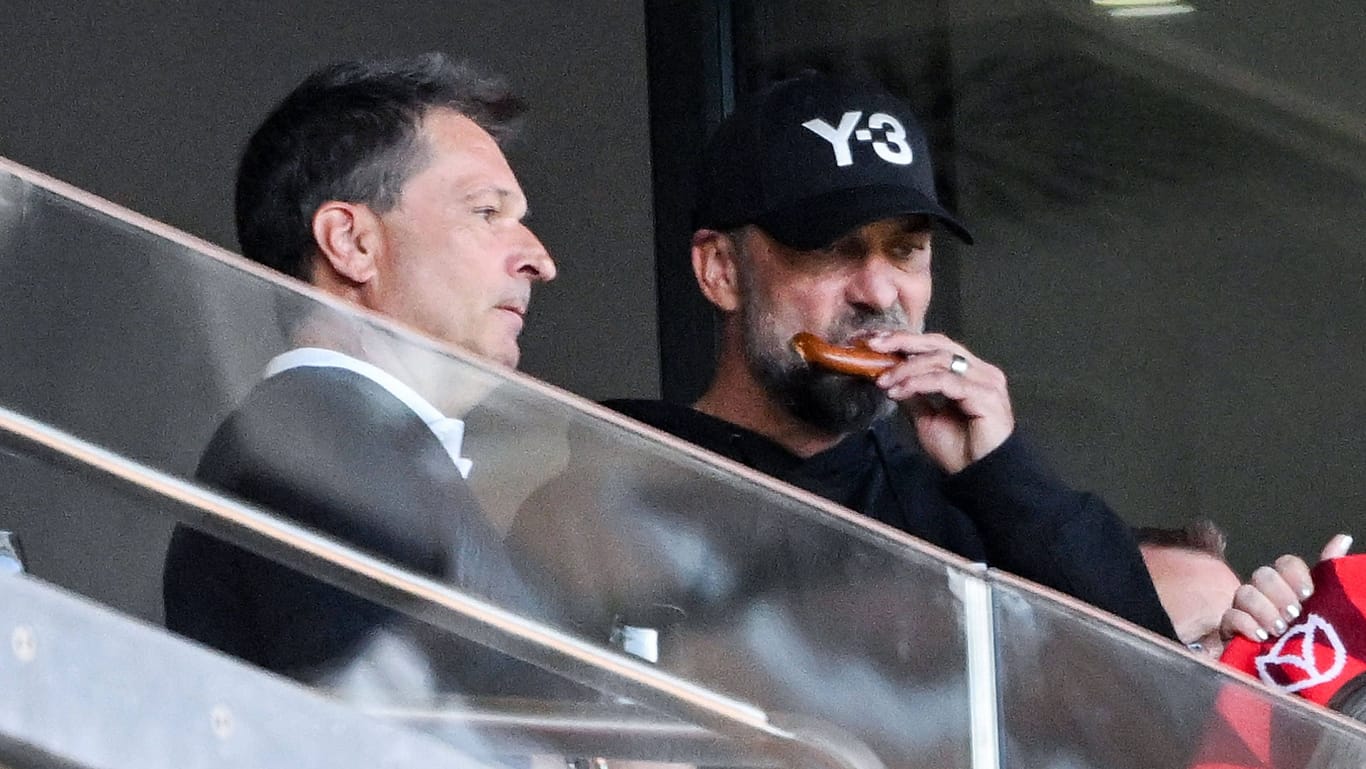 Aufmerksamer Zuschauer beim Ex-Klub: Jürgen Klopp (r., mit Mainz-Vorstandsmitglied Christian Heidel) lässt sich eine Brezel schmecken.