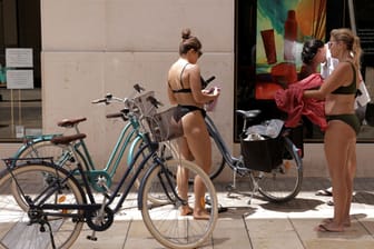 Das soll es bald nicht mehr geben: Touristinnen tragen an einem heißen Sommertag im Stadtzentrum von Málaga nur Bikinis.