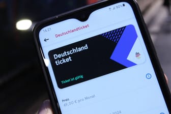 Eine Person hält ein Smartphone, auf dem ein Deutschlandticket in der HVV-App zu sehen ist (Symbolbild): Hamburgs Schüler bekommen das Ticket gratis.