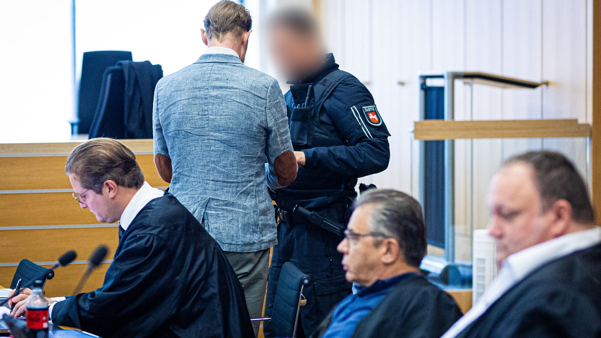 Ein Justizmitarbeiter (r.) löst bei dem Angeklagten Christian B. (l.) die Handfesseln: Die Verteidiger plädieren weiterhin auf Freispruch.