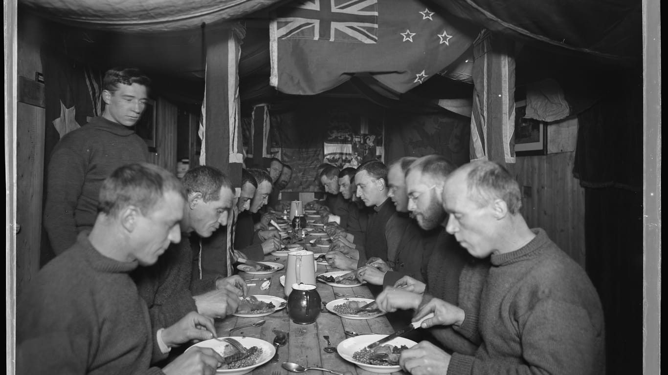 Die Crewmitglieder "Endurance" beim Dinner: Dieses Foto wurde etwa fünf Monate, nachdem das Schiff im Eis stecken geblieben war, geschossen. Laut der Überlebenden gab es Schweineraten mit Apfelmus, Erbsen aus der Dose und einen Plumpudding (ähnlich dem Christmas Pudding).