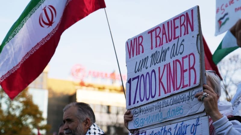 Teilnehmer einer Pro-Palästina Demonstration halten Plakate und iranische Flaggen hoch: Am Wittenbergplatz demonstrieren mehr als 300 Menschen für Solidarität mit Palästina.