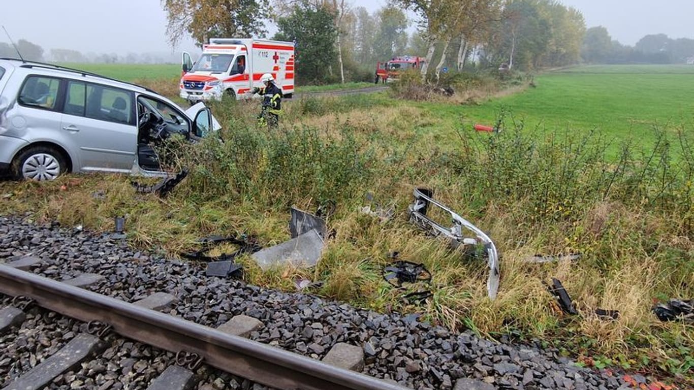 Die von der Freiwillige Feuerwehr Gemeinde Schiffdorf zur Verfügung gestellte Aufnahme zeigt Trümmerteile eines Zugs und Autos neben einer Bahnstrecke während Feuerwehr und Rettungsdienst im Einsatz sind. Für 52 Reisegäste in einem Zug Richtung Bremerhaven endete die Fahrt wegen eines Zusammenstoßes der Bahn mit einem Auto im Landkreis Cuxhaven.