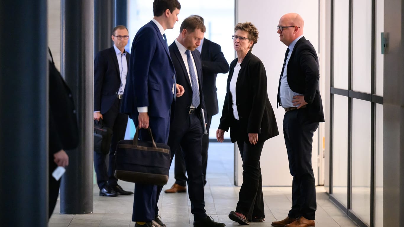 Nach knapp zweistündigen Gesprächen steht Kretschmer gemeinsam mit Homann, Zimmermann und Conrad Clemens (CDU), Chef der Staatskanzlei, vor dem Besprechungsraum.